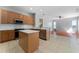 Kitchen with a center island and stainless steel appliances, looking into the living room at 6550 Crestmont Glen Ln, Windermere, FL 34786