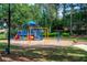 A colorful community playground with slides and swings surrounded by a lush lawn and mature trees at 6550 Crestmont Glen Ln, Windermere, FL 34786
