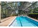 Screened-in pool and spa surrounded by lush landscaping, with a view of the lake at 6550 Crestmont Glen Ln, Windermere, FL 34786