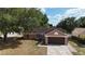 Inviting single-Gathering home with attached garage and mature landscaping, showcasing curb appeal at 7700 Greytwig Ln, Orlando, FL 32818