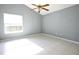 This bedroom features gray walls, a tiled floor, and a ceiling fan at 7700 Greytwig Ln, Orlando, FL 32818