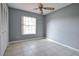 This bedroom features gray walls, a tiled floor, and a ceiling fan at 7700 Greytwig Ln, Orlando, FL 32818