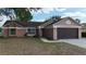 Charming single-story home featuring a well-maintained lawn and a two-car garage at 7700 Greytwig Ln, Orlando, FL 32818