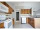 Efficient kitchen with wood cabinets, white appliances, and tile floors, ready for culinary adventures at 7700 Greytwig Ln, Orlando, FL 32818