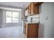 Functional kitchen featuring wood cabinetry, white appliances, and a bright window for natural light at 7700 Greytwig Ln, Orlando, FL 32818