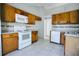 Traditional kitchen featuring wood cabinets, white appliances, and tile backsplash for a cozy cooking space at 7700 Greytwig Ln, Orlando, FL 32818