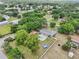 Expansive aerial view of a single-Gathering home featuring a sparkling pool, lush landscaping, and a large, fenced backyard at 7779 Lake Andrea Cir, Mount Dora, FL 32757
