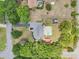 Aerial view showcases the house's layout, highlighting the pool, patio, and mature trees surrounding the property at 7779 Lake Andrea Cir, Mount Dora, FL 32757