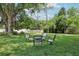 Relaxing backyard setting with four chairs in a circle on lush green grass at 7779 Lake Andrea Cir, Mount Dora, FL 32757