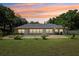 Lovely backyard with a pool, well-maintained lawn, and a beautiful sunset backdrop at 7779 Lake Andrea Cir, Mount Dora, FL 32757