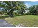 Vast backyard with lush green grass and mature trees, providing a serene and private setting at 7779 Lake Andrea Cir, Mount Dora, FL 32757