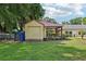 View of shed with red roof and a covered porch area, adding charm to the backyard at 7779 Lake Andrea Cir, Mount Dora, FL 32757