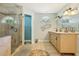 Bright bathroom features a double vanity with granite counters and a walk-in shower at 7779 Lake Andrea Cir, Mount Dora, FL 32757