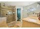 Bright bathroom with a glass shower, decorative sink, tile floors, and ample lighting at 7779 Lake Andrea Cir, Mount Dora, FL 32757