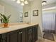 Stylish bathroom featuring a dark vanity, tiled floors, and a shower with a curtain at 7779 Lake Andrea Cir, Mount Dora, FL 32757