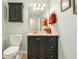 Elegant bathroom featuring a dark vanity with stone counters and a toilet at 7779 Lake Andrea Cir, Mount Dora, FL 32757