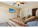 Comfortable bedroom featuring a ceiling fan, wall-mounted TV, and double closet at 7779 Lake Andrea Cir, Mount Dora, FL 32757