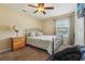 Comfortable bedroom with a ceiling fan, window with blinds, and dark carpet at 7779 Lake Andrea Cir, Mount Dora, FL 32757