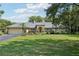 Charming single Gathering home with a lush green lawn and beautifully landscaped front yard at 7779 Lake Andrea Cir, Mount Dora, FL 32757