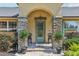 Inviting front entrance with a stone pillar entryway and meticulously maintained landscaping at 7779 Lake Andrea Cir, Mount Dora, FL 32757