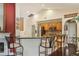 Well-lit kitchen with stainless steel appliances, wooden cabinets, and granite countertops at 7779 Lake Andrea Cir, Mount Dora, FL 32757