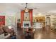 Cozy living room with a fireplace, mirror and open layout flowing into the kitchen area at 7779 Lake Andrea Cir, Mount Dora, FL 32757