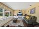 Bright living room featuring hardwood floors, plush seating, and expansive windows at 7779 Lake Andrea Cir, Mount Dora, FL 32757