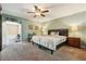 Spacious main bedroom with carpet floors, ceiling fan, and natural light from doorway at 7779 Lake Andrea Cir, Mount Dora, FL 32757