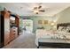 Spacious main bedroom with carpet floors, ceiling fan, and natural light from doorway at 7779 Lake Andrea Cir, Mount Dora, FL 32757