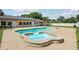 An inviting backyard featuring a uniquely shaped pool with an attached spa, perfect for relaxation and recreation at 7779 Lake Andrea Cir, Mount Dora, FL 32757