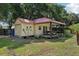 Shed with a red roof, covered porch and pool table, perfect for outdoor activities at 7779 Lake Andrea Cir, Mount Dora, FL 32757