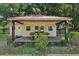 Shed with a red roof and covered porch, creating a fun outdoor game space at 7779 Lake Andrea Cir, Mount Dora, FL 32757