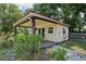 Charming shed with a red roof and covered porch, adding character to the backyard at 7779 Lake Andrea Cir, Mount Dora, FL 32757