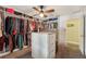 Spacious walk-in closet featuring custom shelving, an island dresser, and a ceiling fan for added comfort at 7779 Lake Andrea Cir, Mount Dora, FL 32757