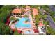 Aerial view showcases a stunning community pool with palm trees, lounge chairs, and lush landscaping at 8000 Tuscany Way # 4408, Davenport, FL 33896