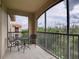 Covered balcony with seating and view of lush greenery and distant buildings at 8000 Tuscany Way # 4408, Davenport, FL 33896