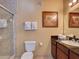 Bathroom with tiled shower, granite countertop, and a decorative painting at 8000 Tuscany Way # 4408, Davenport, FL 33896