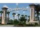 View of the Champions Gate entrance with palm trees, fountain and lush landscaping at 8000 Tuscany Way # 4408, Davenport, FL 33896
