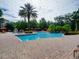 Large community pool with palm trees, cabanas, and a lush landscape in a Mediterranean setting at 8000 Tuscany Way # 4408, Davenport, FL 33896