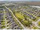 Aerial view of a Primary-planned community with tree-lined streets, a central park, and well-maintained homes at 8058 Corkfield Ave, Orlando, FL 32832