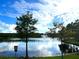 Lake with water fountain and greenery, community access with sign at 8058 Corkfield Ave, Orlando, FL 32832