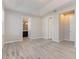 Primary bedroom boasting a tray ceiling, ensuite bathroom, and light wood-look floors at 8058 Corkfield Ave, Orlando, FL 32832
