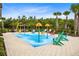 Colorful splash pad with playful water features, surrounded by lounge chairs and tropical palm trees at 8058 Corkfield Ave, Orlando, FL 32832