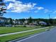 Neighborhood street view featuring well-manicured lawns and attractive two-story homes under a bright blue sky at 8058 Corkfield Ave, Orlando, FL 32832