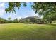A large backyard with a view of the home, lush trees, and a screened-in pool area at 9138 Pinnacle Cir, Windermere, FL 34786