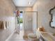 Bright bathroom features a glass-enclosed shower, toilet, and a vanity with a sink at 9138 Pinnacle Cir, Windermere, FL 34786
