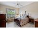 Traditional bedroom with a four-poster bed, tiled floor, and a sofa under the window at 9138 Pinnacle Cir, Windermere, FL 34786