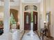 Grand entrance showcasing double doors, high ceilings with chandelier, and elegant tile flooring at 9138 Pinnacle Cir, Windermere, FL 34786