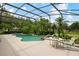 Screened-in pool area with mature landscaping, waterfall feature, and patio seating at 9138 Pinnacle Cir, Windermere, FL 34786