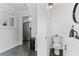 All-white bathroom with sleek fixtures, wainscoting, neutral walls, and views into the kitchen at 1017 Florida Ave, St Cloud, FL 34769